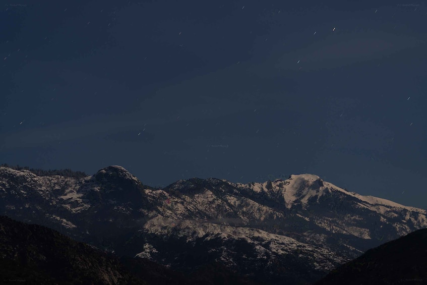 A mountain range with snow-capped peaks under a starry night sky. 3