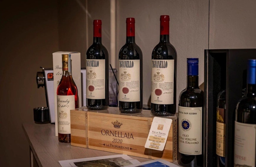 A selection of wine bottles on a wooden display with labels indicating they are from the Ornellaia 2020 vintage. 4