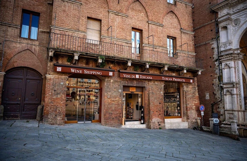 A historic brick building with a wine shipping store and a Tuscan products shop. 5