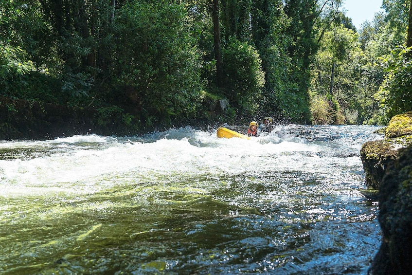 Rafting auf wilden Wassern mit einem gelben Schlauchboot, das durch tosende Strömungen in dichtem Wald manövriert. 5