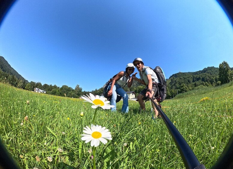 Two people hiking in a grassy field with a mountain in the background. 3