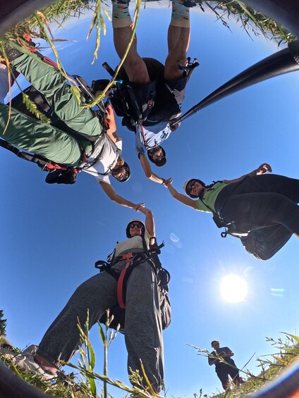 A group of people preparing for a skydiving jump with parachutes and harnesses. 2