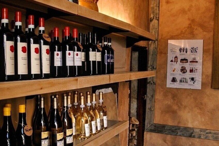 A wine cellar with shelves of wine bottles and a poster on the wall. 2