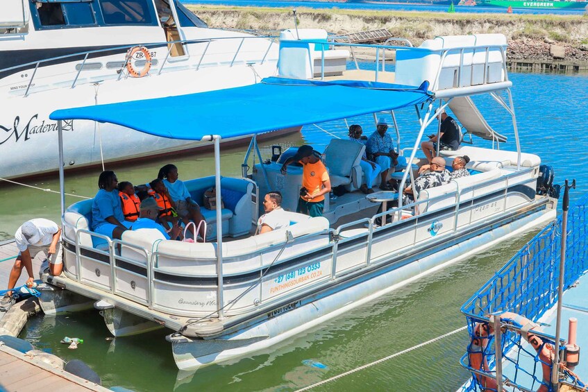 A boat with people on board, a lifebuoy, and a contact number. 4