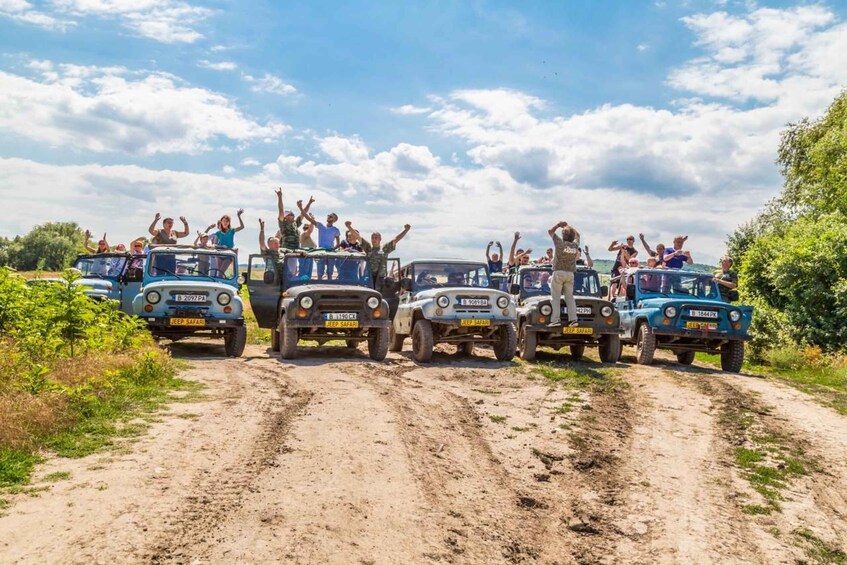 A group of people on safari vehicles on a dirt road. 3