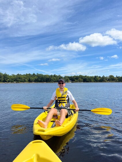A person kayaking on a calm lake with a clear sky. 2