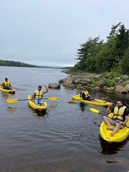People kayaking on a calm river surrounded by rocks and trees. 4
