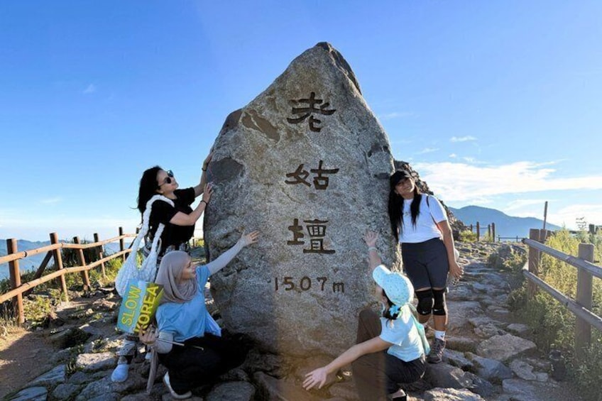 A large rock with inscriptions and a height marker of 1507m. 3