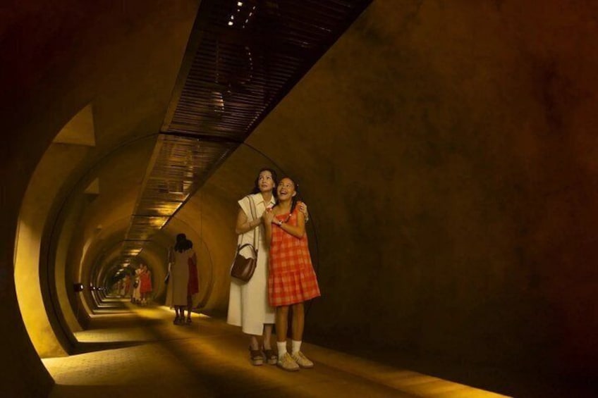 A tunnel with a curved ceiling and a reflective floor. 3