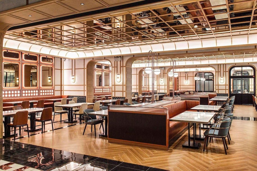 A spacious restaurant with high ceilings, wooden paneling, and a mix of booth and table seating. 2
