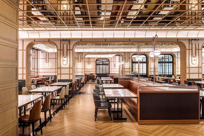 A spacious restaurant with high ceilings, wooden paneling, and large windows. 4