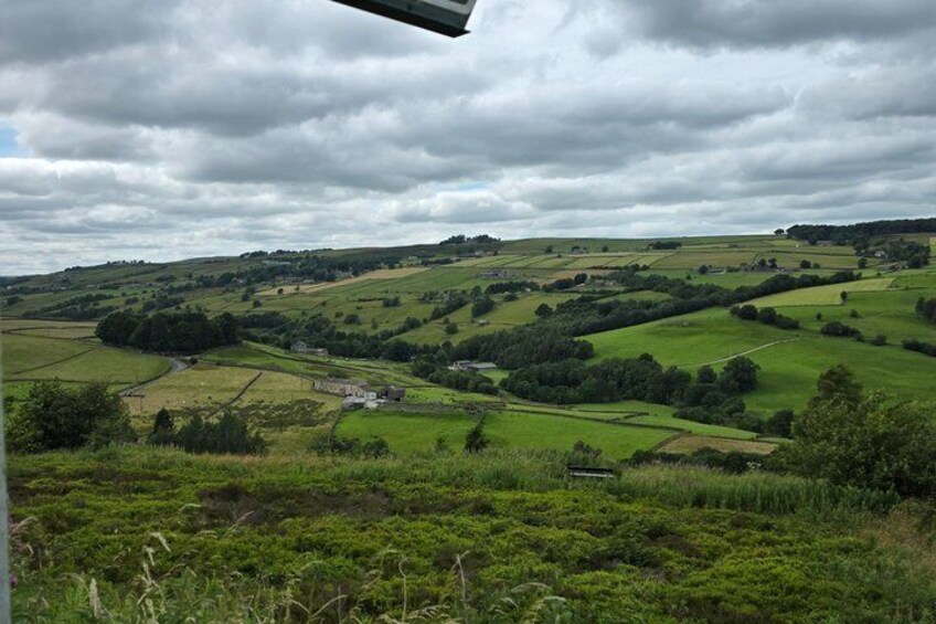 Rolling green hills, a winding road, and a cloudy sky. 3