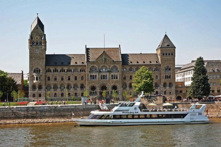 A historic building with a tower, a river, and a boat. 5