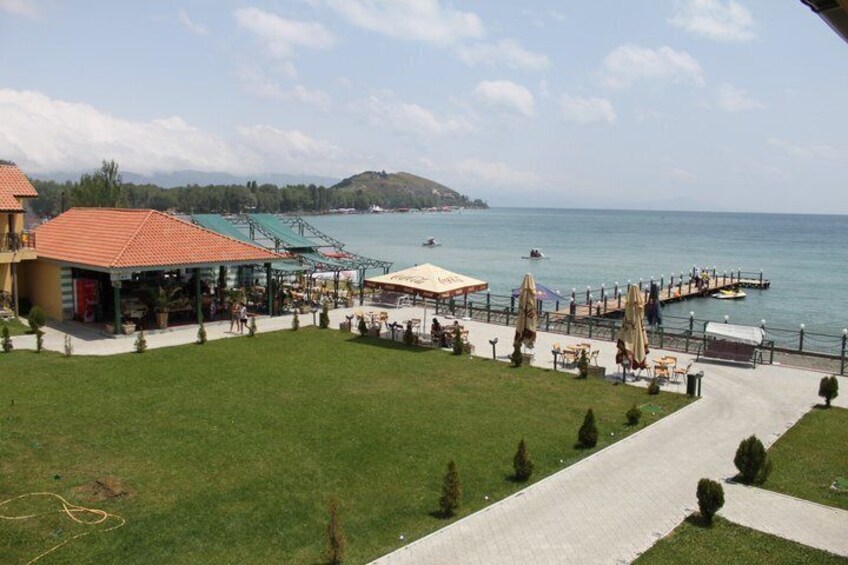 A coastal area with a pier, grassy areas, and a building with a red roof. 2