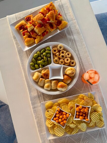 A table with various snacks including bread, edamame, cheese puffs, and crisps. 2