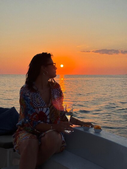 A person sitting by the sea during sunset. 4