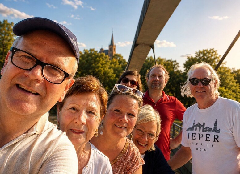 A group of people outdoors, with a church spire in the background. 4