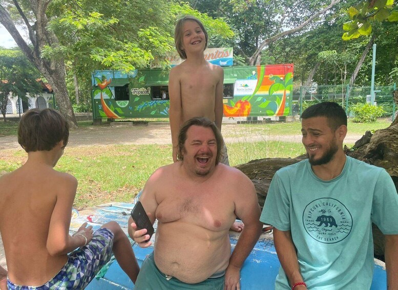A group of people sitting by a pool with a colorful mural in the background. 3