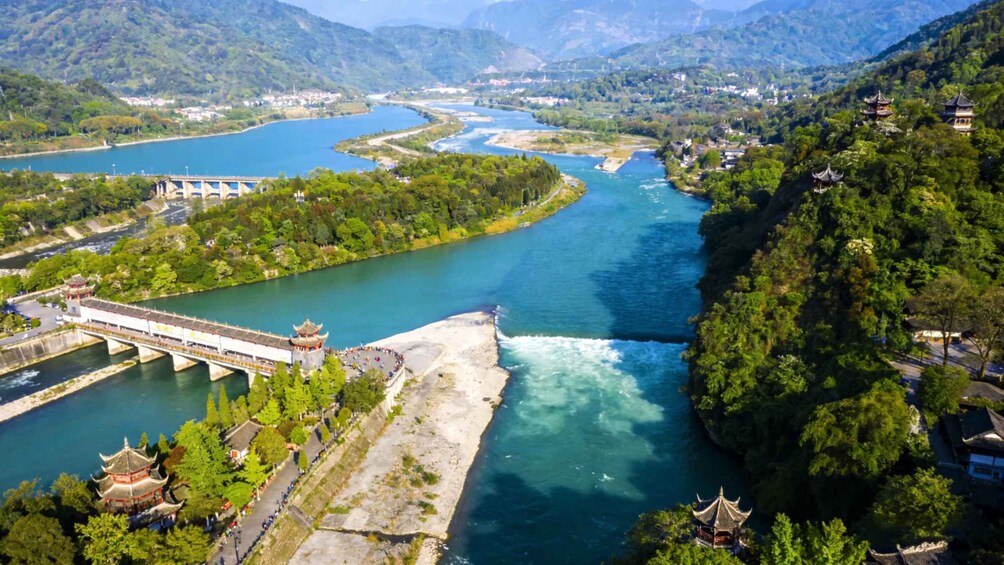 A river with a bridge, traditional architecture, and surrounding greenery. 5