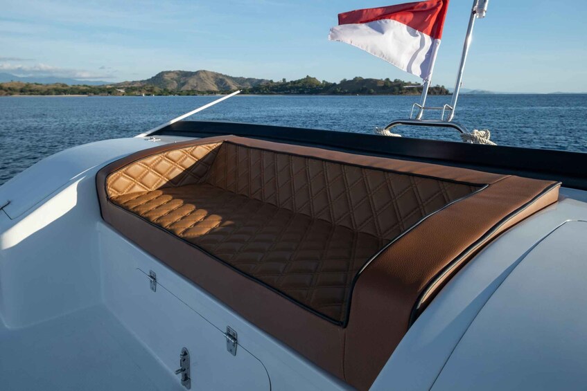 A boat's interior with a cushioned seating area and a flag. 3
