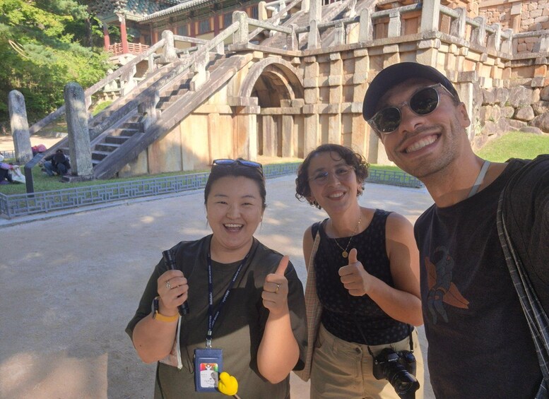 A group of people posing in front of a historic stone bridge with a staircase. 3