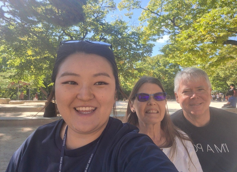 A group of people in an outdoor setting with trees and a clear sky. 4