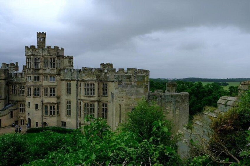 A historic castle with multiple towers and battlements, surrounded by lush greenery. 2