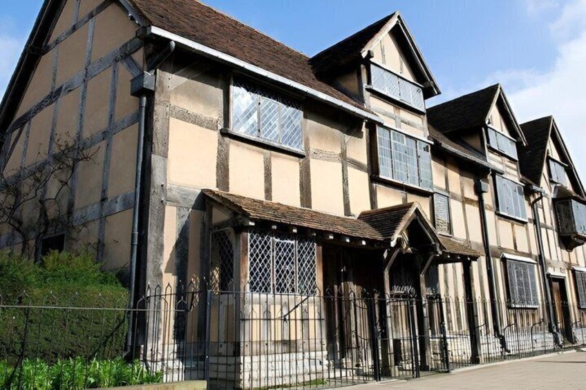 A traditional half-timbered building with a steep roof, large windows, and a gated entrance. 4