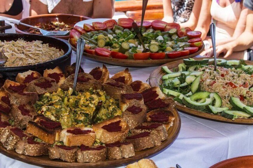 A variety of dishes including a large platter of sliced bread, a salad, and a couscous dish. 2