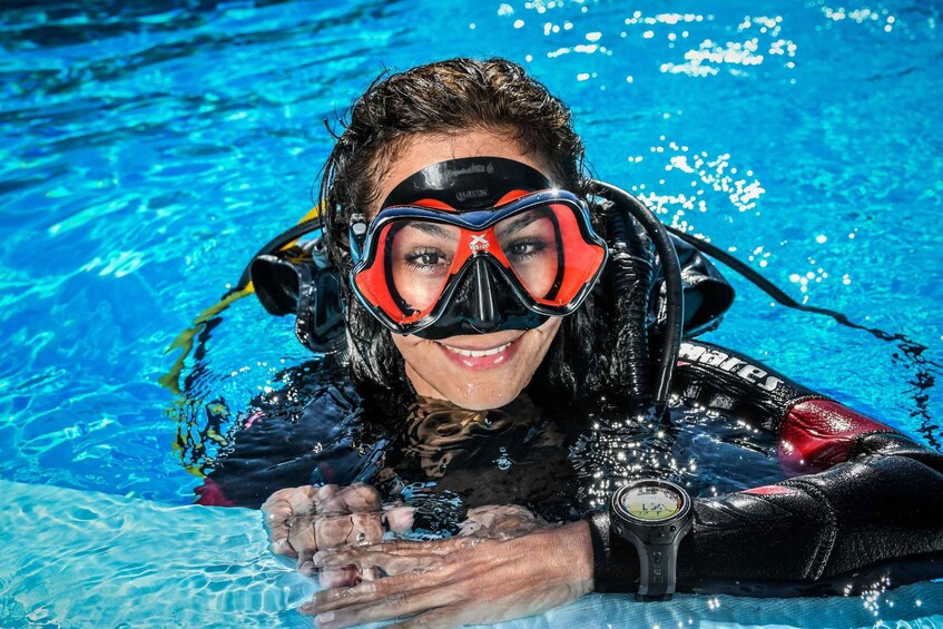 A person in a pool wearing a scuba diving mask and fins. 2