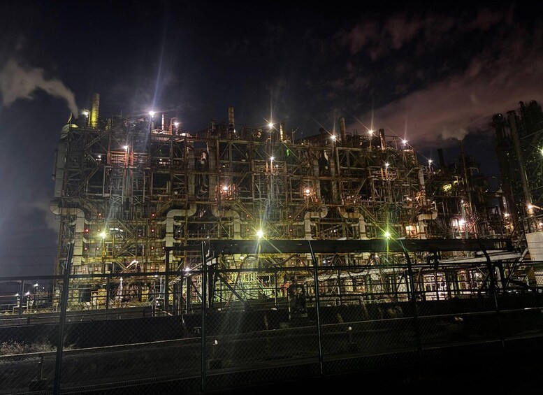 An industrial complex at night with multiple structures and pipes, illuminated by artificial lights. 5