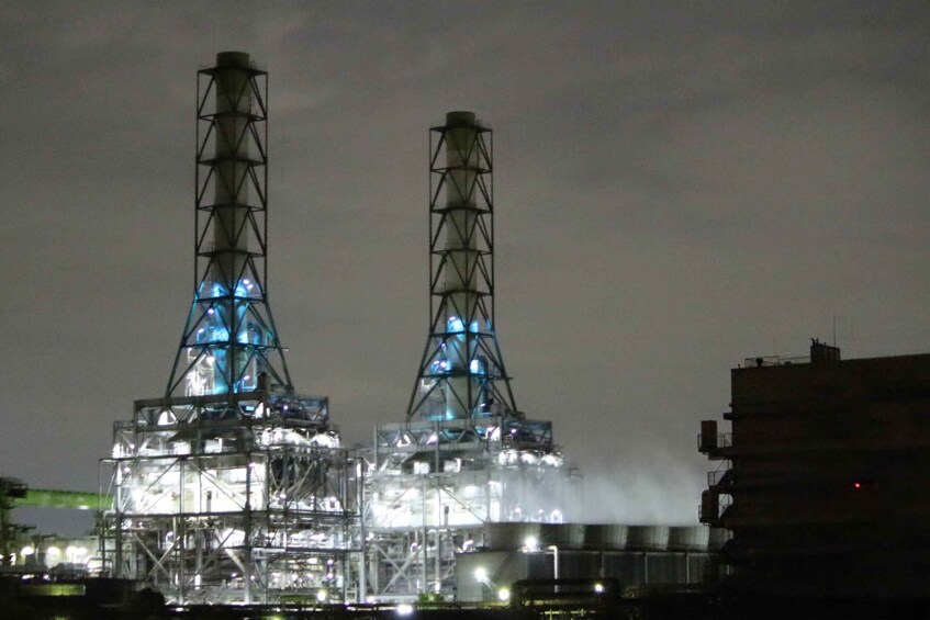 Two industrial towers with a complex framework, illuminated by internal lighting. 1