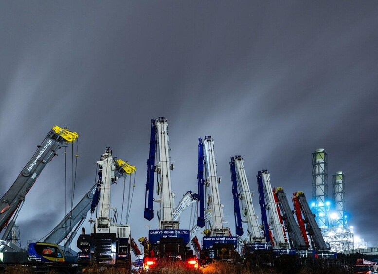 A construction site at night with multiple cranes and industrial equipment. 2