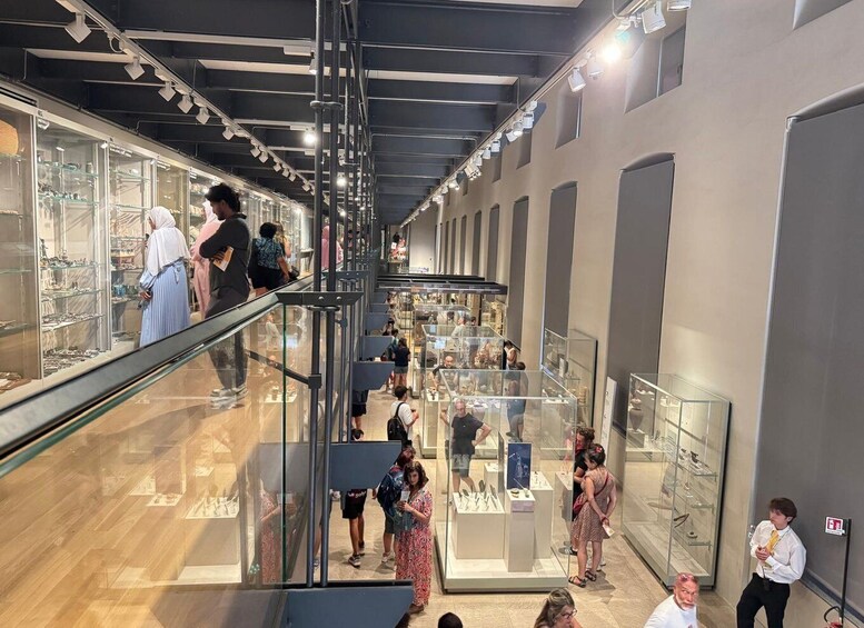 An indoor museum with glass display cases and visitors. 5