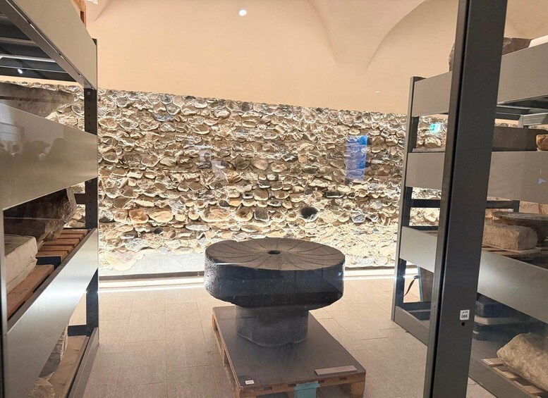 A stone wall with a circular stone structure in the foreground. 2