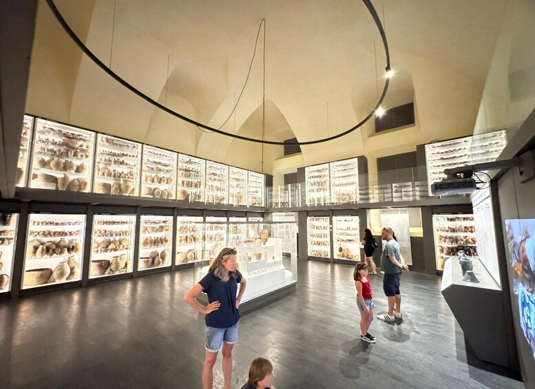 An indoor museum with glass display cases containing pottery. 4