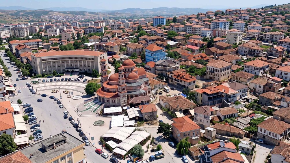 A densely populated urban area with a mix of residential buildings and a prominent historical building with domes. 1