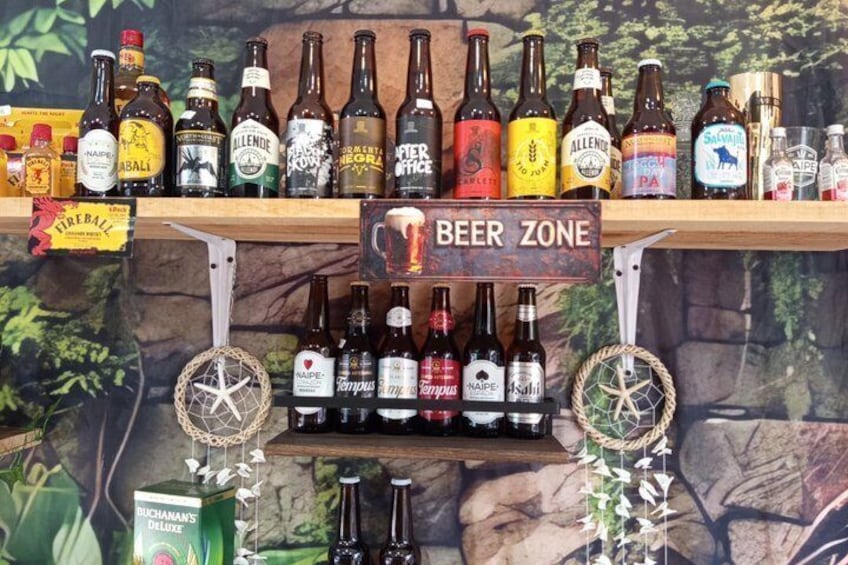 A variety of beer bottles on shelves with a 'Beer Zone' sign. 1