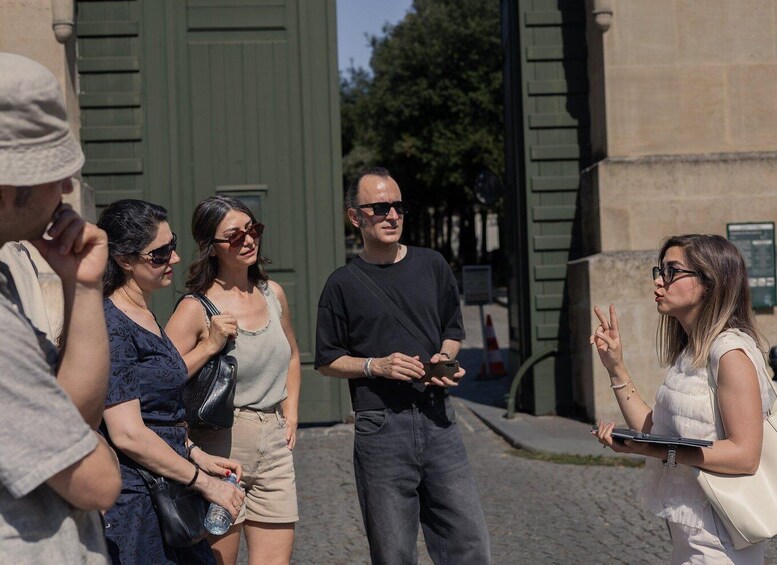 A group of people standing on a cobblestone street, engaged in conversation. 4