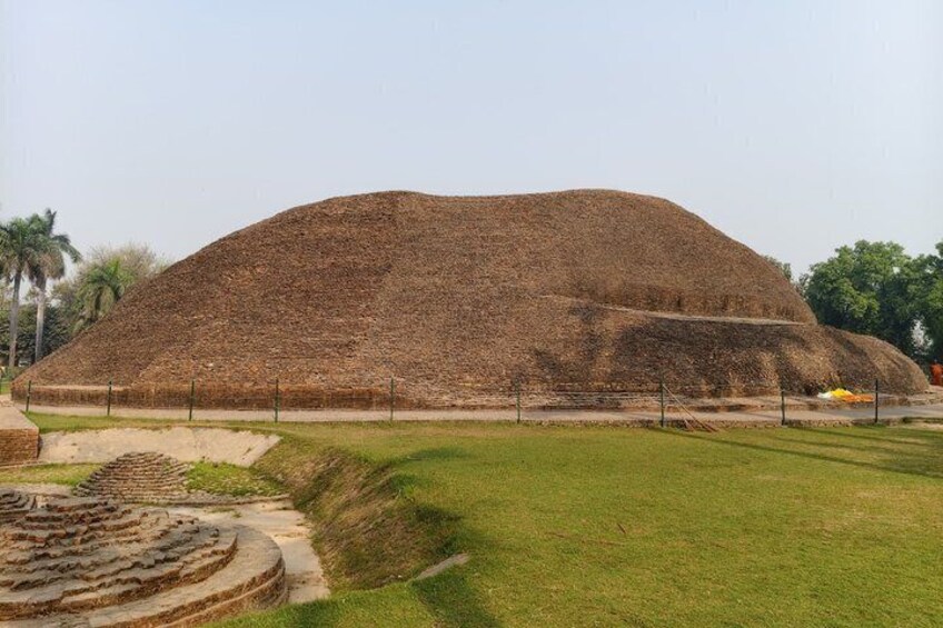 A large mound of earth, possibly a mound or hill, with a pathway leading up to it. 5