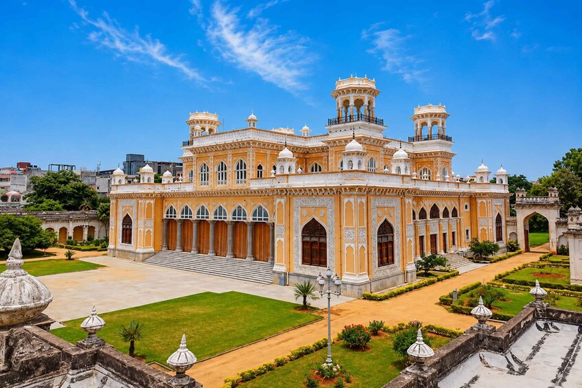 A grand, ornate building with multiple domes and arches, surrounded by well-manicured gardens and pathways. 5