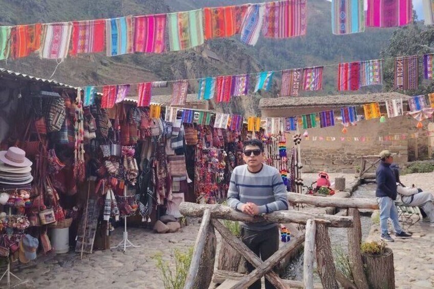 A market stall with colorful textiles and a person sitting in the foreground. 5