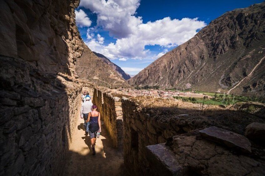 A narrow canyon path with travelers walking. 1