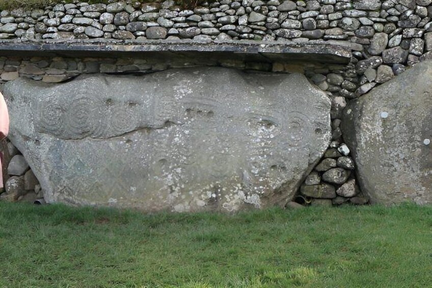 A stone wall with large boulders and a grassy area in front. 5