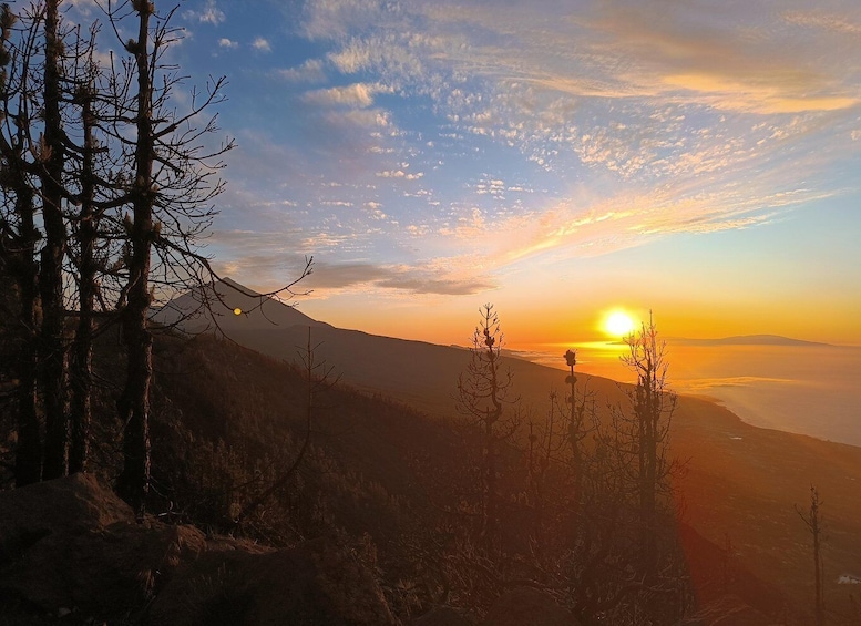 A sunset over a mountainous landscape with sparse vegetation. 2