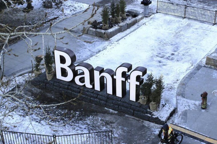 A snow-covered parking lot with a sign that reads 'Banff.' 1