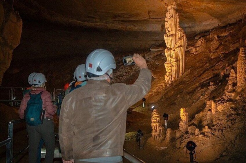 A group of people in a cave with stalactites. 4