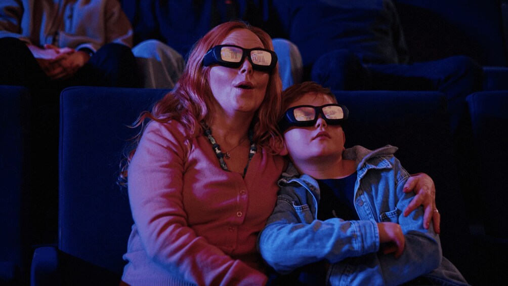 Deux personnes portant des lunettes de réalité virtuelle sont assises dans une salle obscure. 4