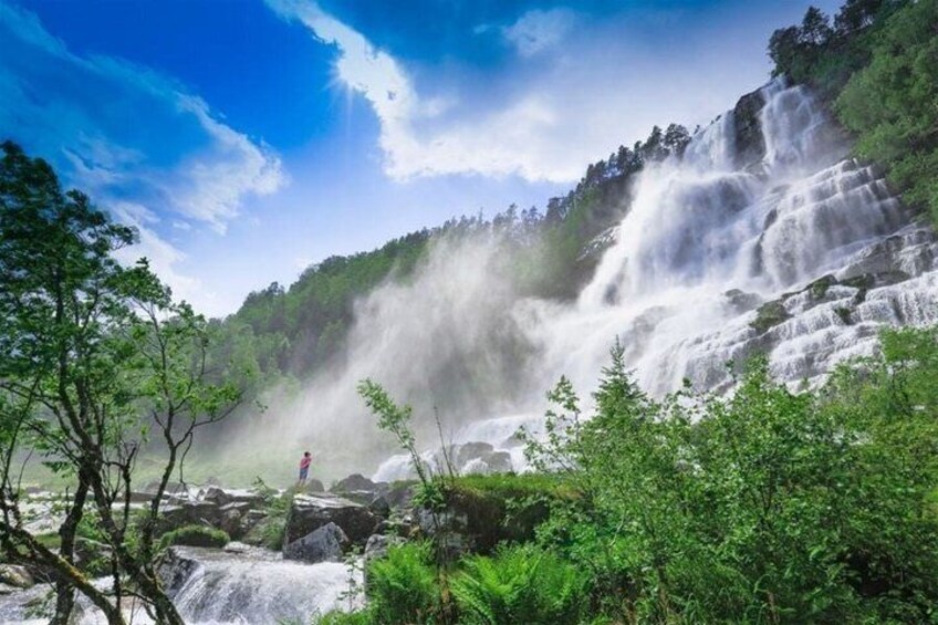 A waterfall cascading down a rocky cliff surrounded by lush greenery. 5