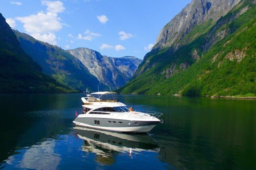 A yacht on a calm lake surrounded by mountains. 1